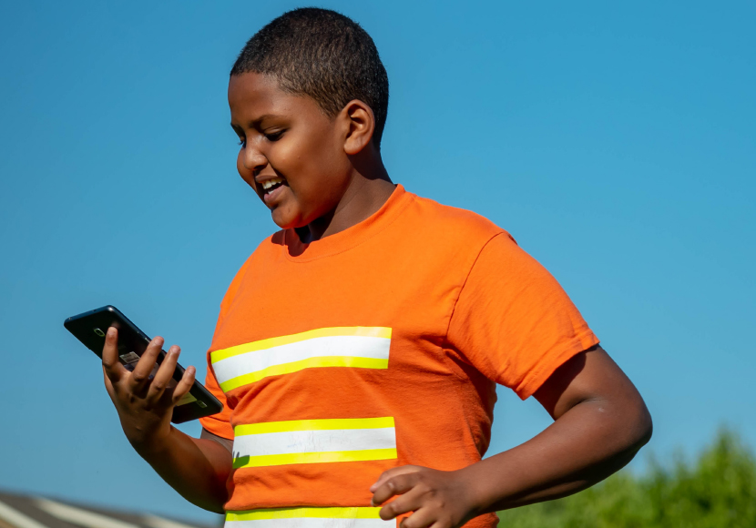 Young patron using a mobile device at a Summer of Learning event