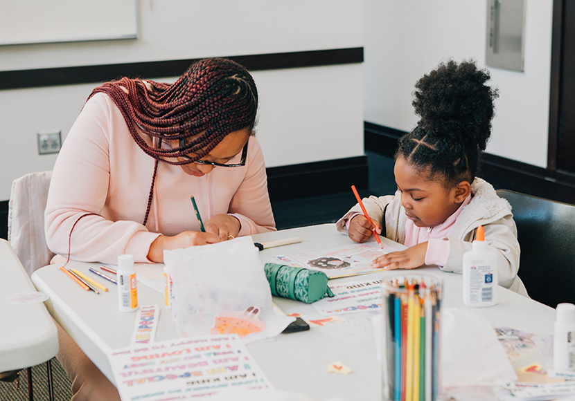 Adult working at a table with a child