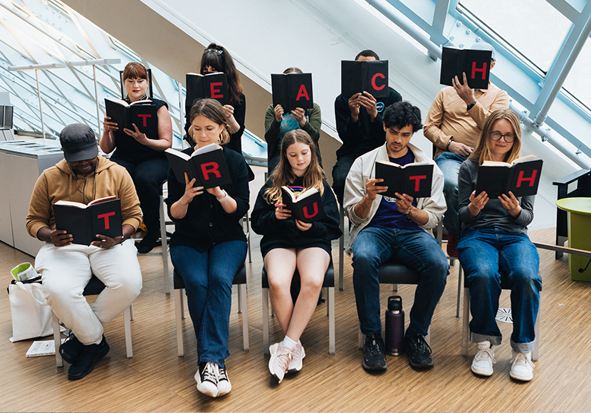 Ten people posed reading books; letters on the cover of each book spell TEACH TRUTH