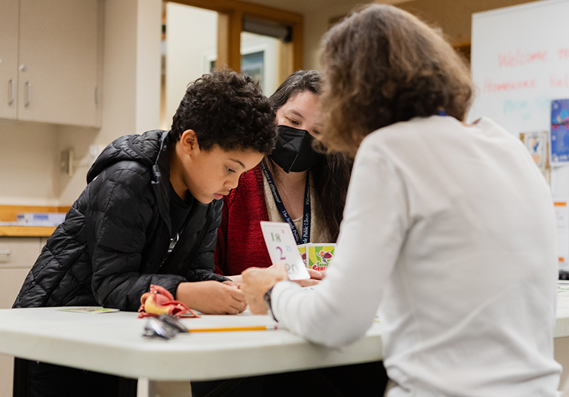 Adult with flash card speaking to two children