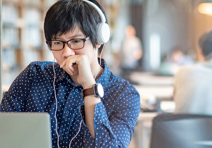 Person wearing headphones looking at laptop display