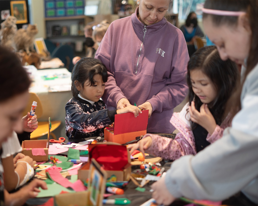 Adults and children gathered around a table with activities