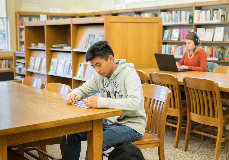 Library patron using a tablet in the reading area at the Green Lake Branch