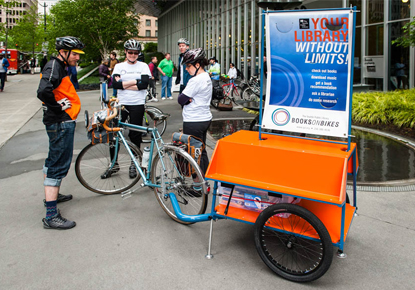 library staff on bikes with books