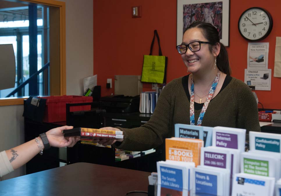 Library staff at the service desk area at the NewHolly Branch