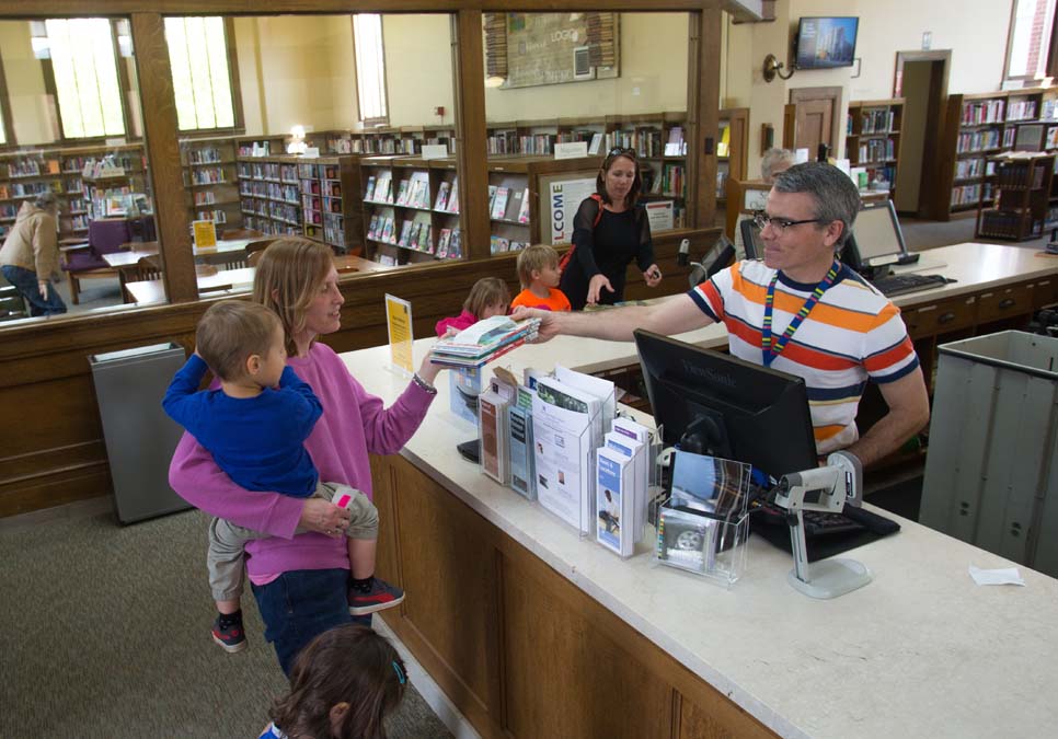 Library patron at service desk area at the West Seattle Branch