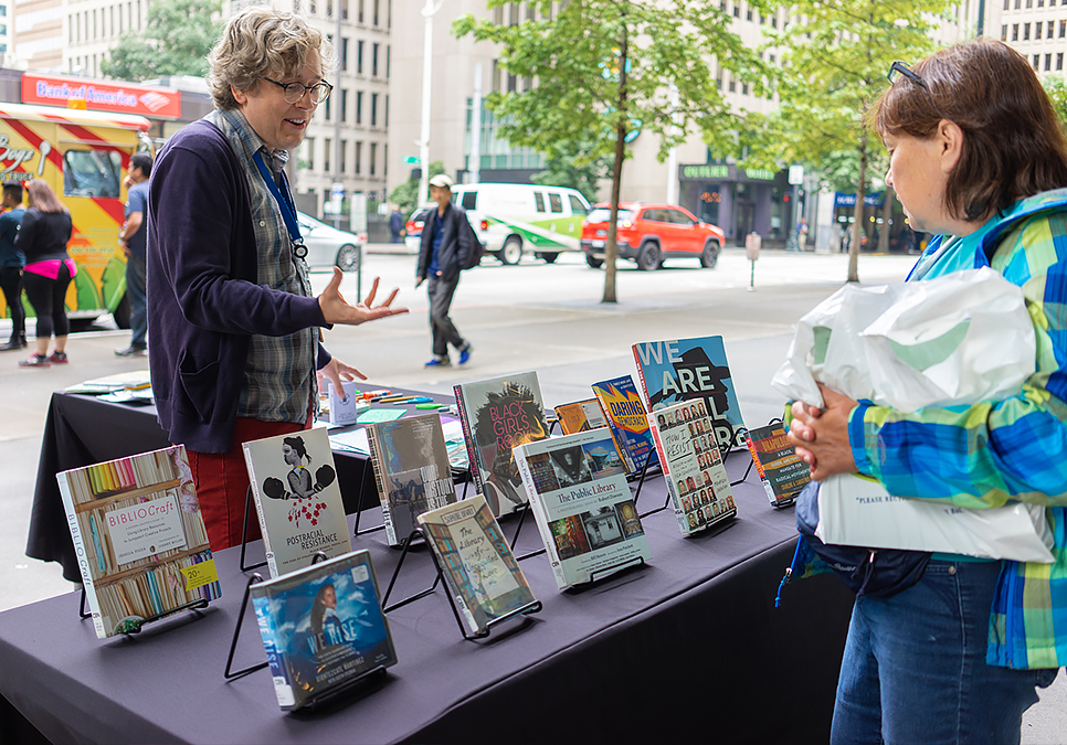 Library staff interacting with patron at art on the plaza event at the Central Library