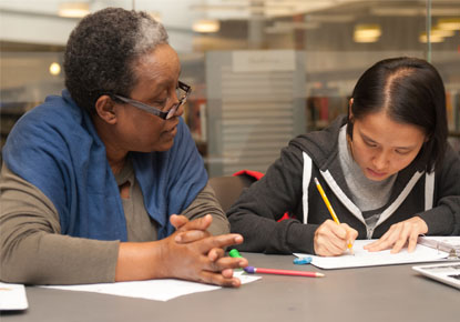 Girl getting homework help with an adult volunteer