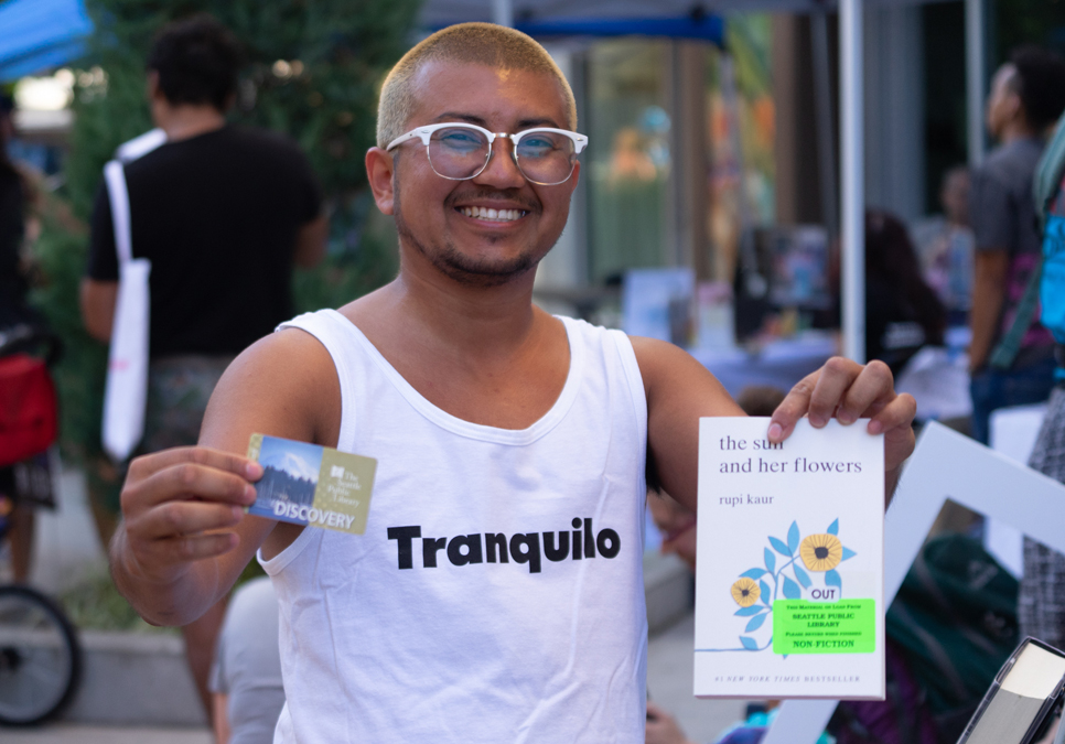 Library patron checking out a book at Seattle Latinx Pride in 2019