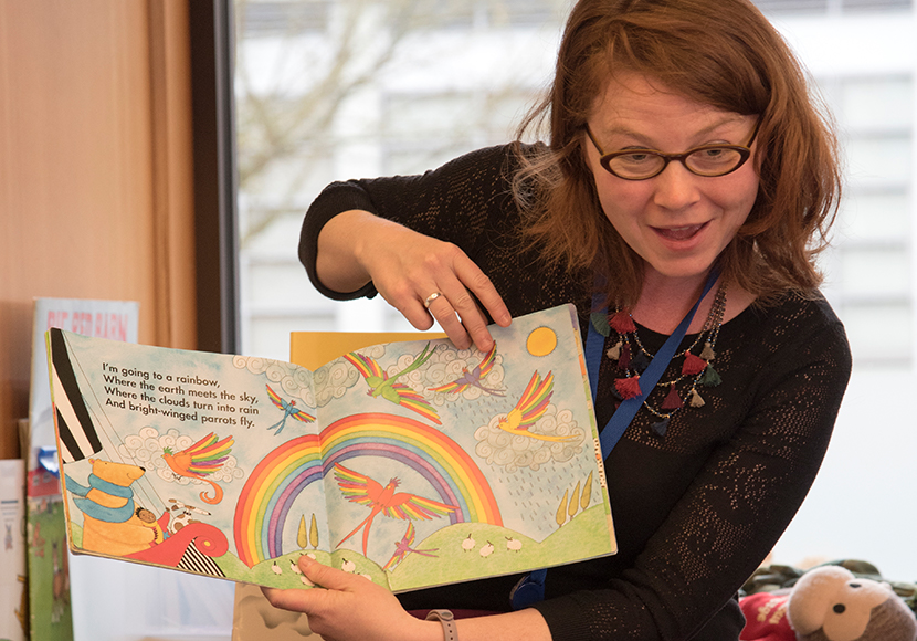Childrens Librarian reading to kids at Rainbow Story Time