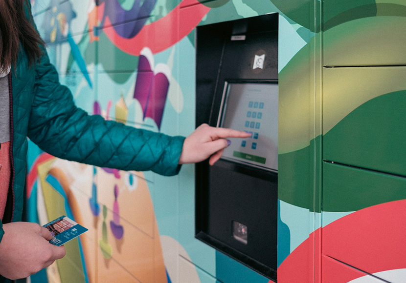 A person entering a library card number and PIN on a touch screen