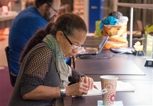 woman writing her book at a Seattle Writes event